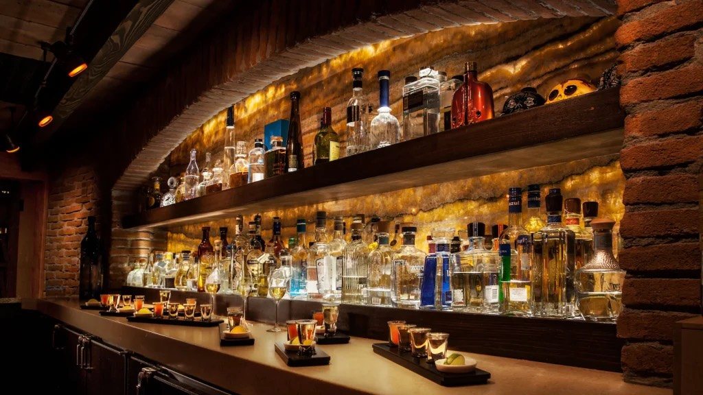 La Cava del Tequila: stone-and-brick cave bar with shelves of bottles and tasting flights on the counter