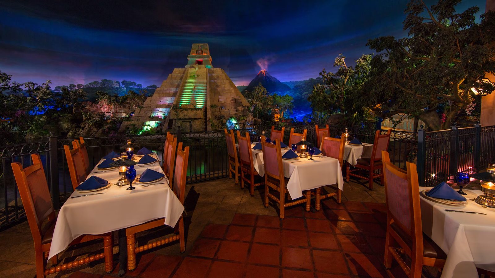 San Angel Inn Restaurante at EPCOT: dining tables at perpetual twilight with a stepped pyramid and volcano beyond